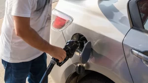 A man refuels his vehicle and thinks about the effects of the new NVES regulations in Australia